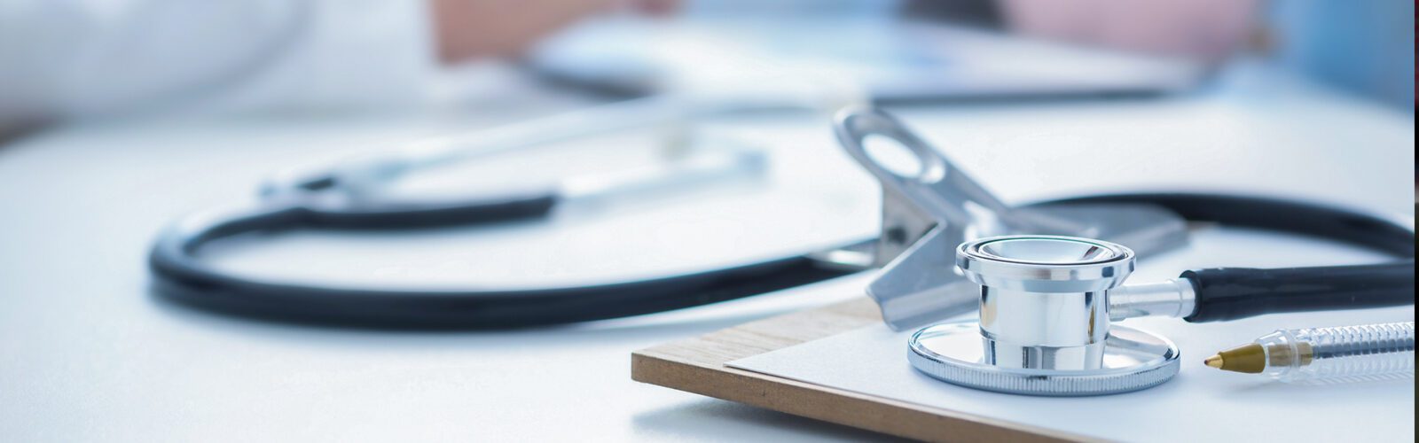 Stethoscope and clip board on the doctor workplace close up