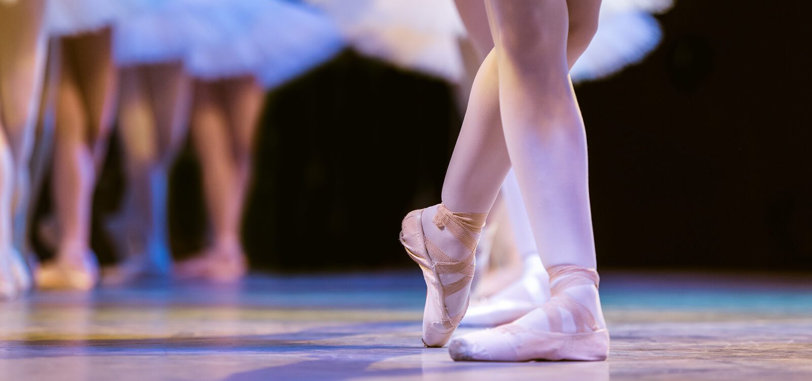 Legs of ballerinas dancing in ballet Swan Lake.